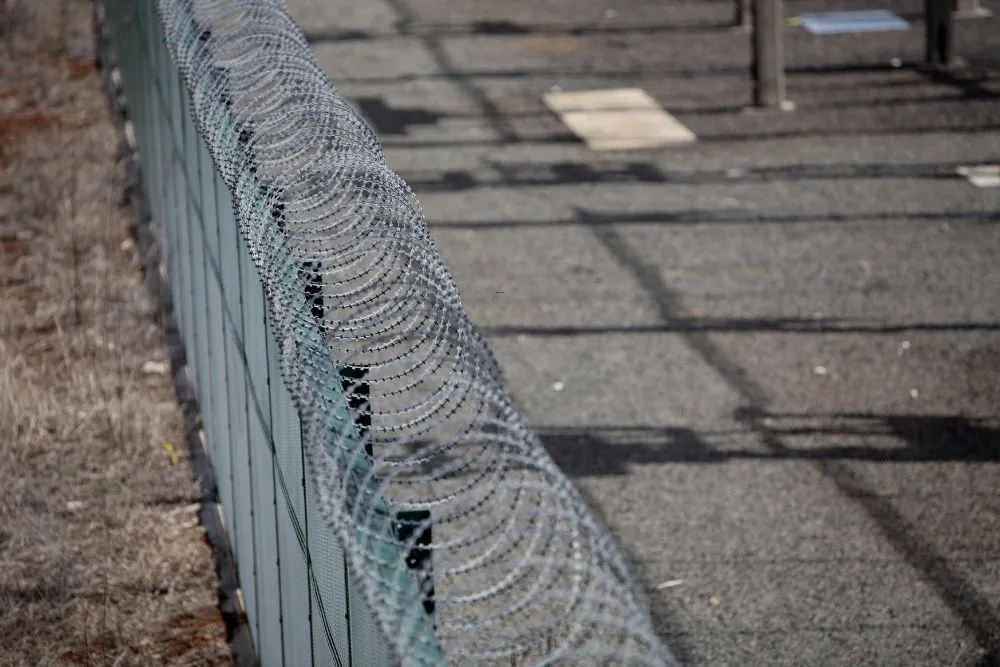 Steel and chainwire security perimeter fence around a commercial yard