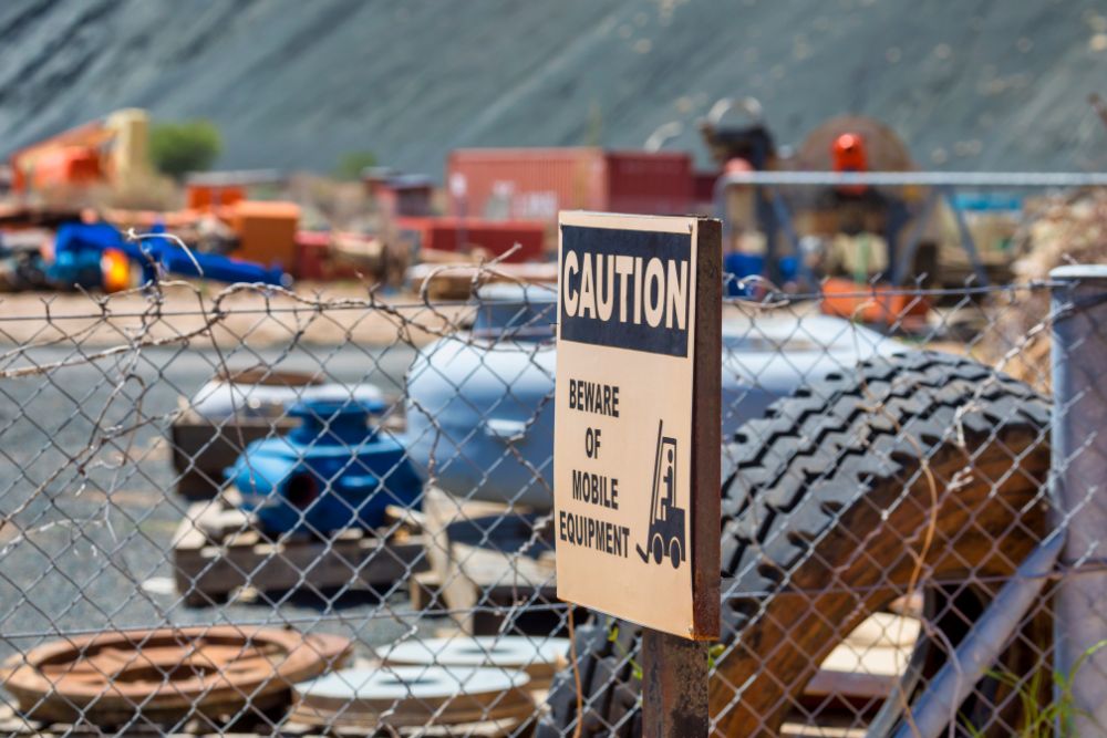 Fenced storage yard with caution sign by Chainwire Fencing Specialist