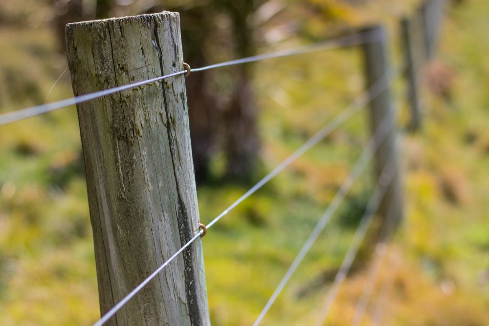 Close-up of plain wire fencing post installed by Chainwire Fencing Specialist
